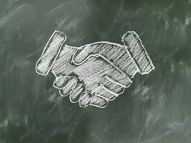 Handschlag aus Kreide auf Tafel gemalt